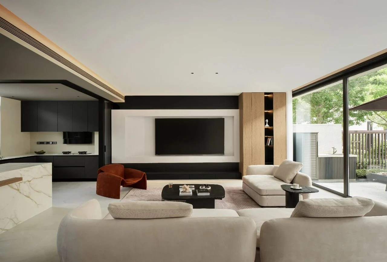 Finished living room with media wall and adjacent kitchen
